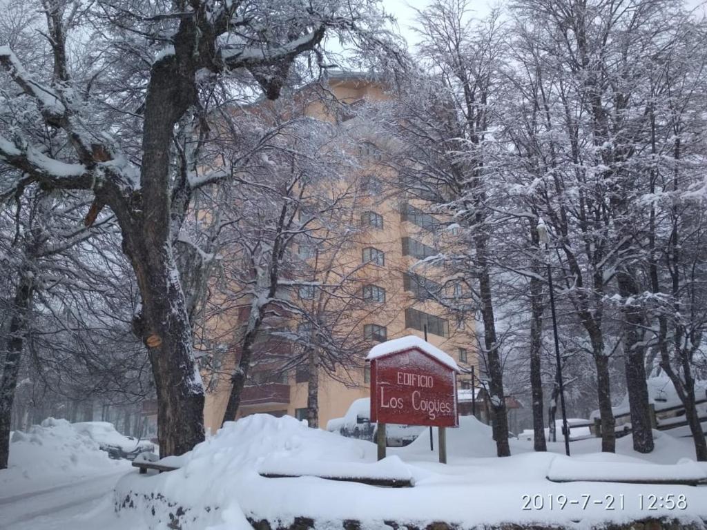 un cartel en la nieve frente a un edificio en Bosque Nevado, en Nevados de Chillán