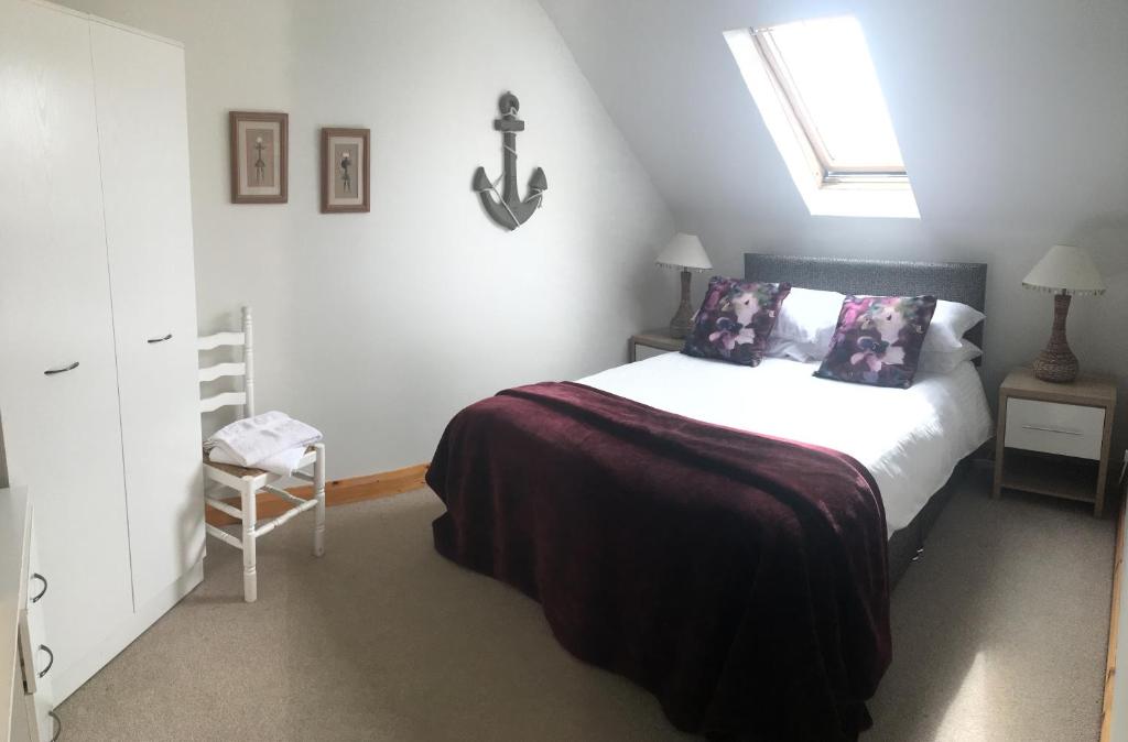 a bedroom with a bed and a skylight at Comfy House in Portstewart