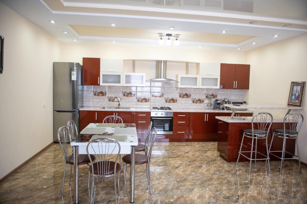 eine Küche mit einem Tisch und Stühlen sowie einem Kühlschrank in der Unterkunft Затишна оселя in Mischhirja