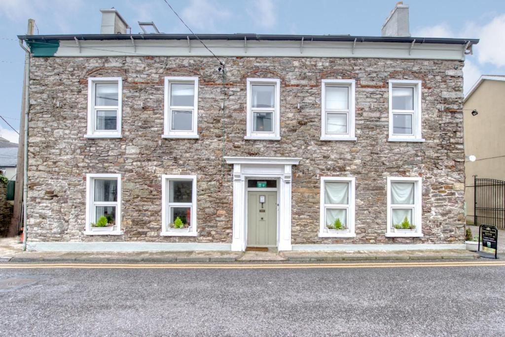 a brick house with white windows and a door at Abbey View House in Youghal