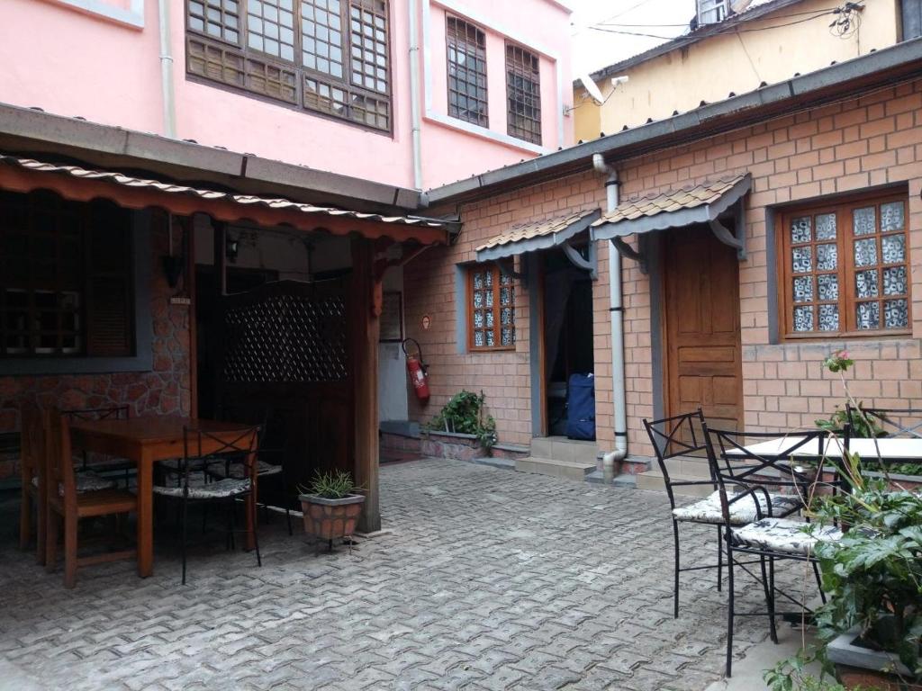 a patio with a table and chairs in front of a building at Hotel St-Antoine in Antananarivo