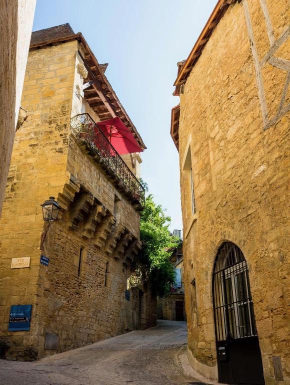 une ruelle dans un vieux bâtiment en pierre avec un portail dans l'établissement Appartements Les Suites sarladaises, à Sarlat-la-Canéda