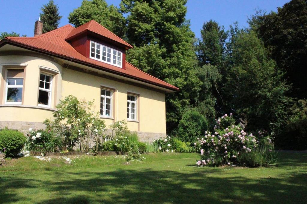 a house with a red roof in a yard at Villa Bergmann in Münchberg