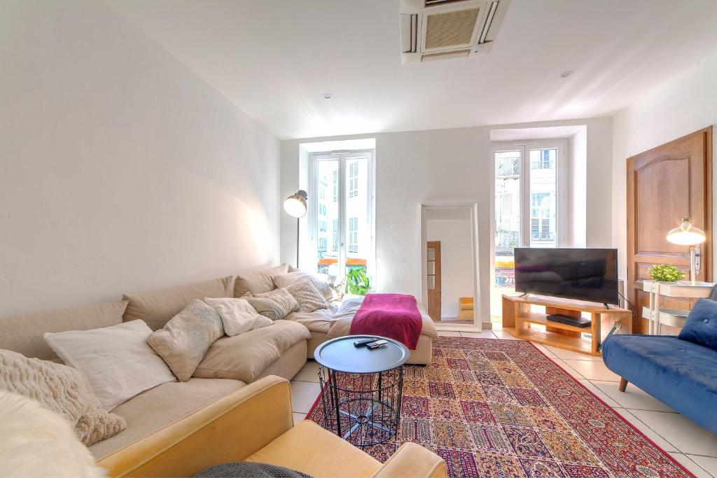 uma sala de estar com um sofá e uma televisão em Lovely large familial apartment in central Nice, ten minutes walk to the beach! em Nice