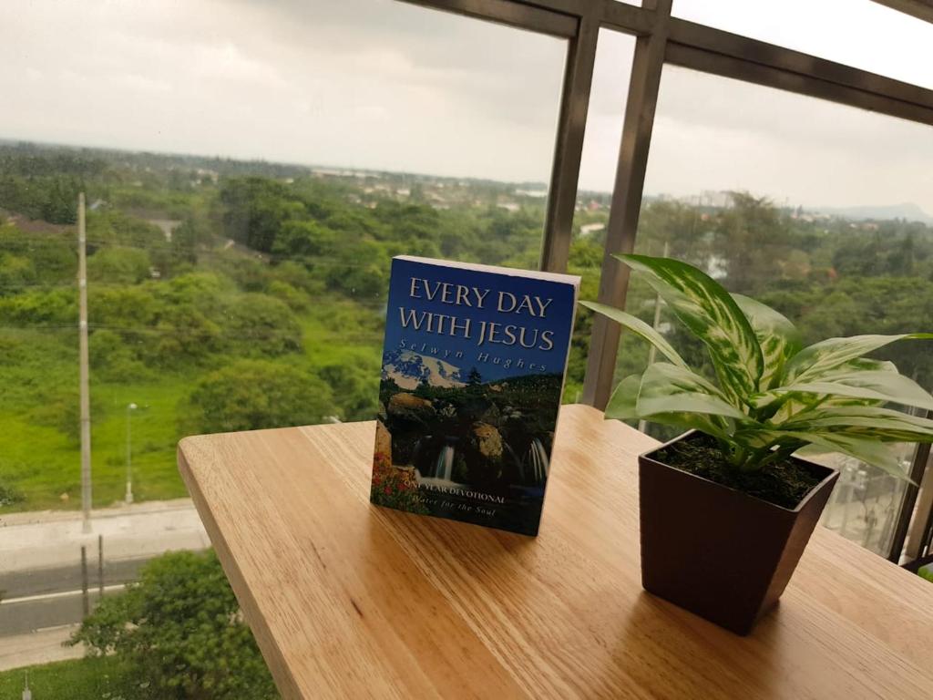 ein Buch auf einem Tisch neben einer Pflanze in der Unterkunft Cool Suites at Wind Residences Tagaytay Staycation- IM HANA 1 in Tagaytay