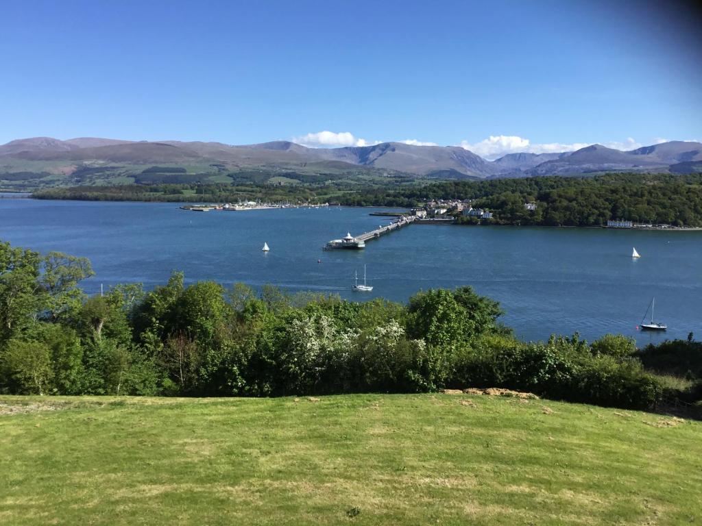 a view of a lake with boats in the water at Coed y Berclas guest room, wonderful view in Llandegfan