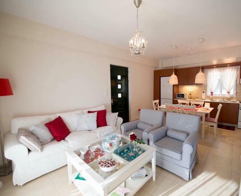 una sala de estar con un sofá y una mesa en Seaside Family House, en Nikiana