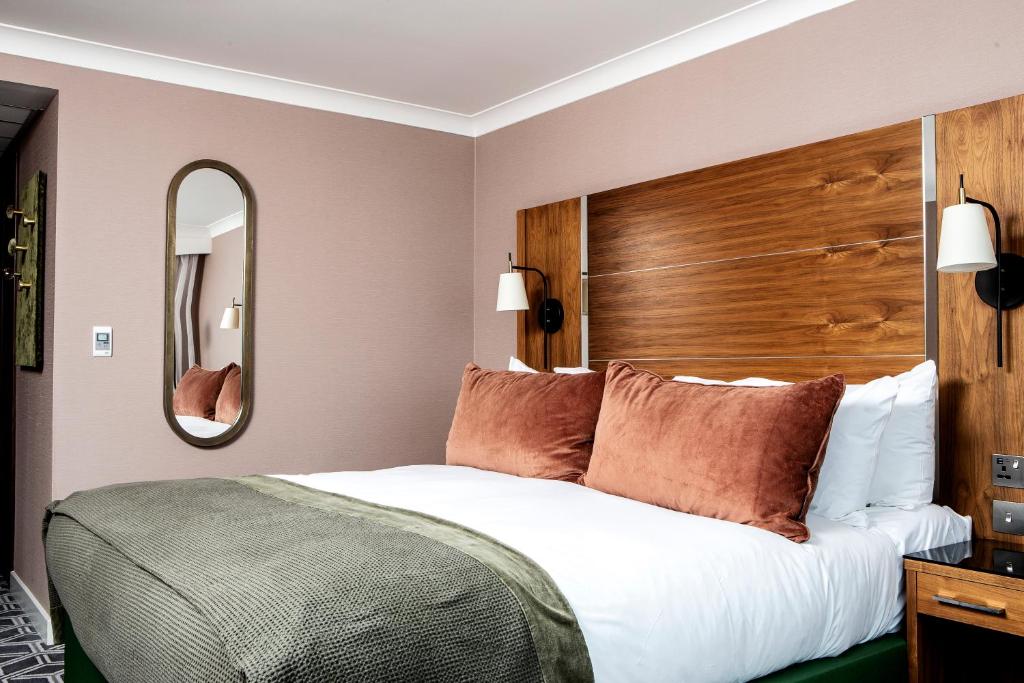 a bedroom with a large bed with a wooden headboard at Waterfront Southport Hotel in Southport