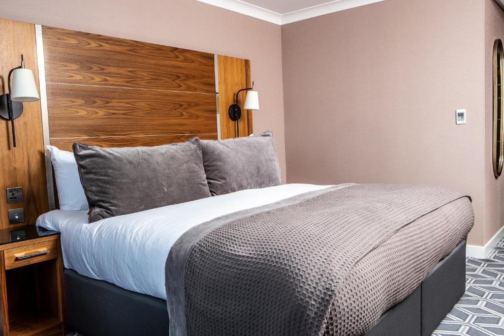 a bedroom with a large bed and a wooden headboard at Waterfront Southport Hotel in Southport