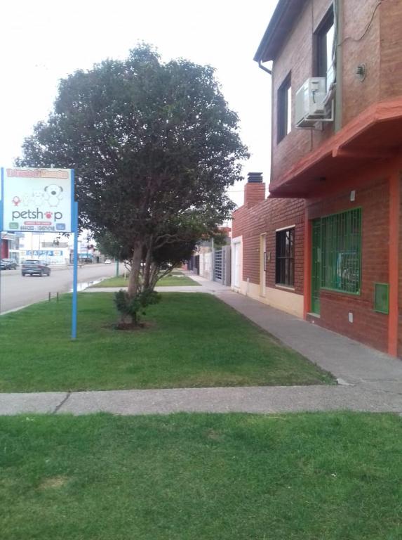 a sign on the side of a building with a tree at Casa Mandala in Trelew