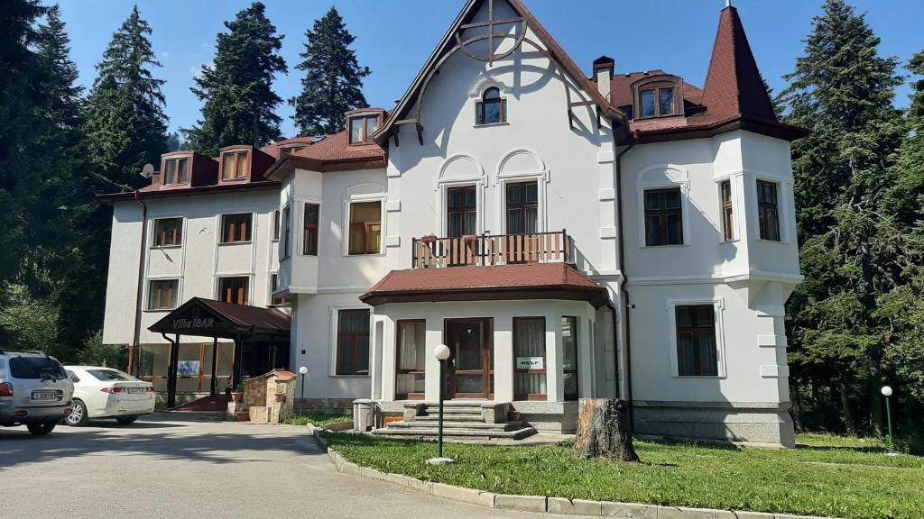 a large white house with a roof at Villa Ibar in Borovets