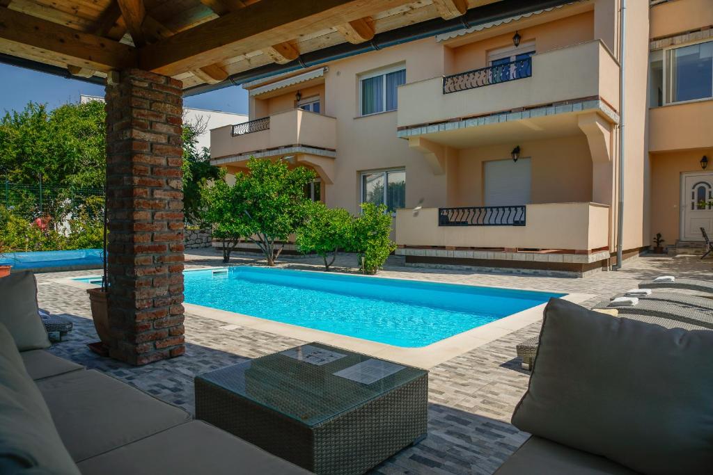 a swimming pool in front of a building at Apartments Juric in Rab