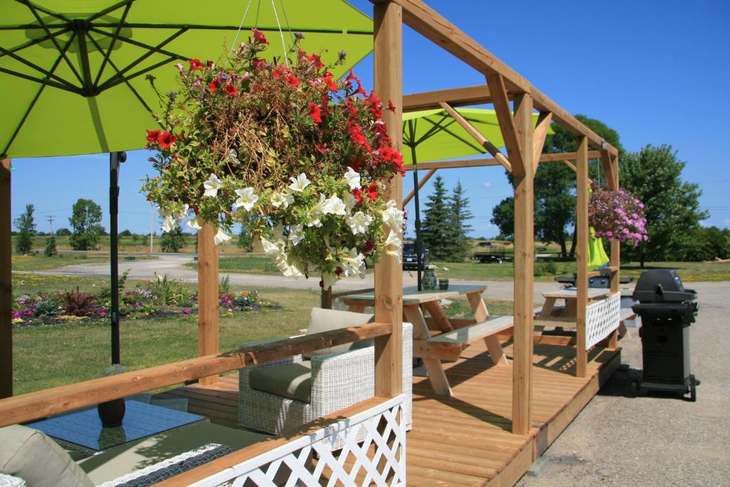a wooden gazebo with a bunch of flowers at Wayside Motel Manitoulin in Manitowaning
