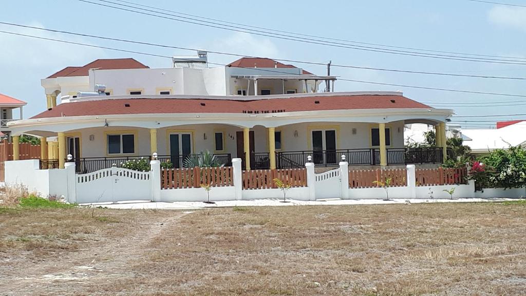 a large house with a white fence in front of it at Self contained apartment with private kitchen Higher Heights, Barbados in Christ Church