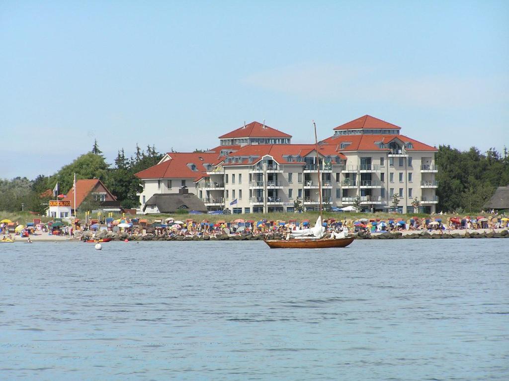 a boat in the water in front of a large building at Strandburg in Burgtiefe auf Fehmarn 