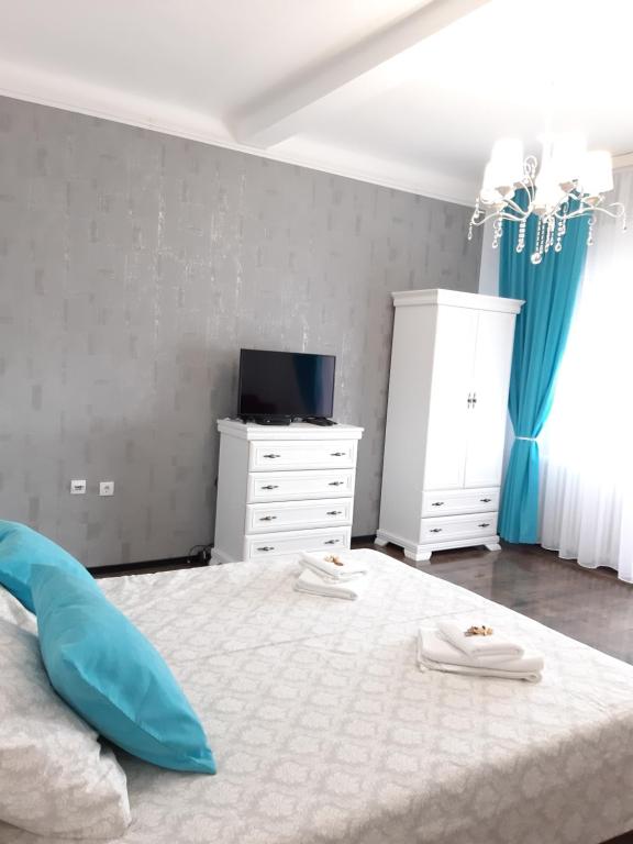 a bedroom with a white bed and a tv at Apartment Zorana-Center in Novi Sad