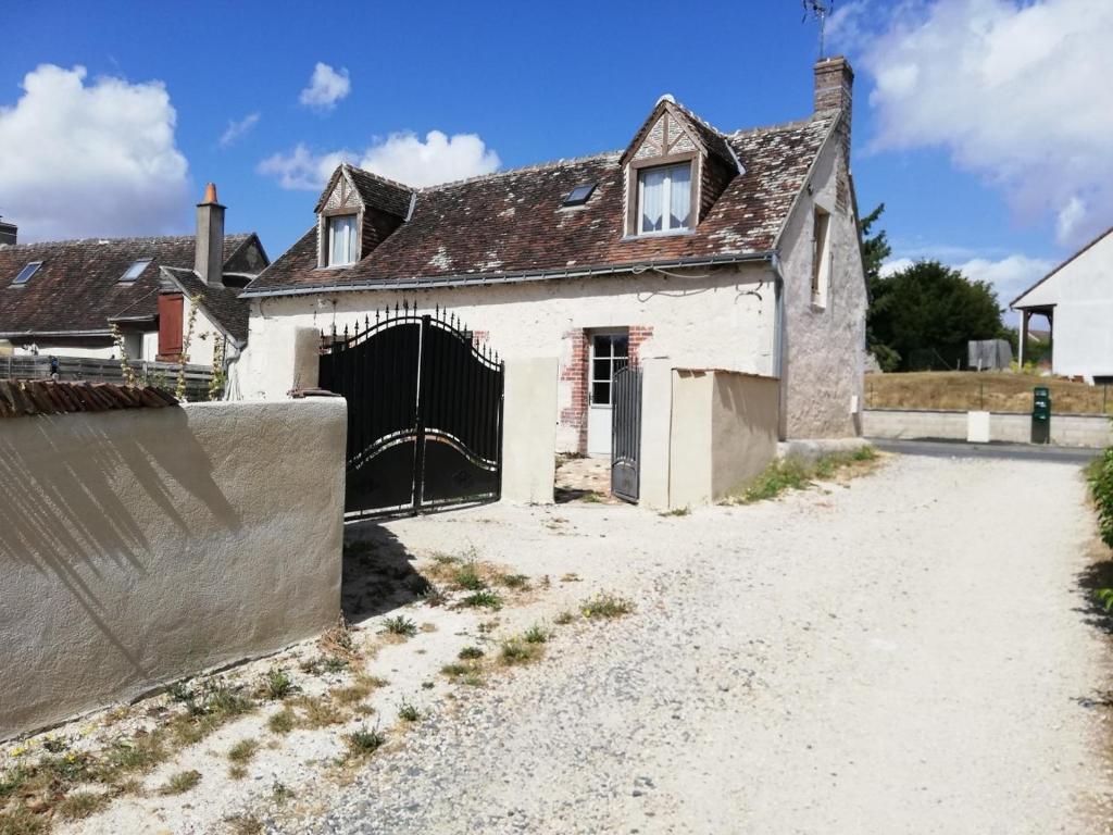 une maison ancienne avec un portail et une allée dans l'établissement Chambre d'hôte Monthodon, à Monthodon