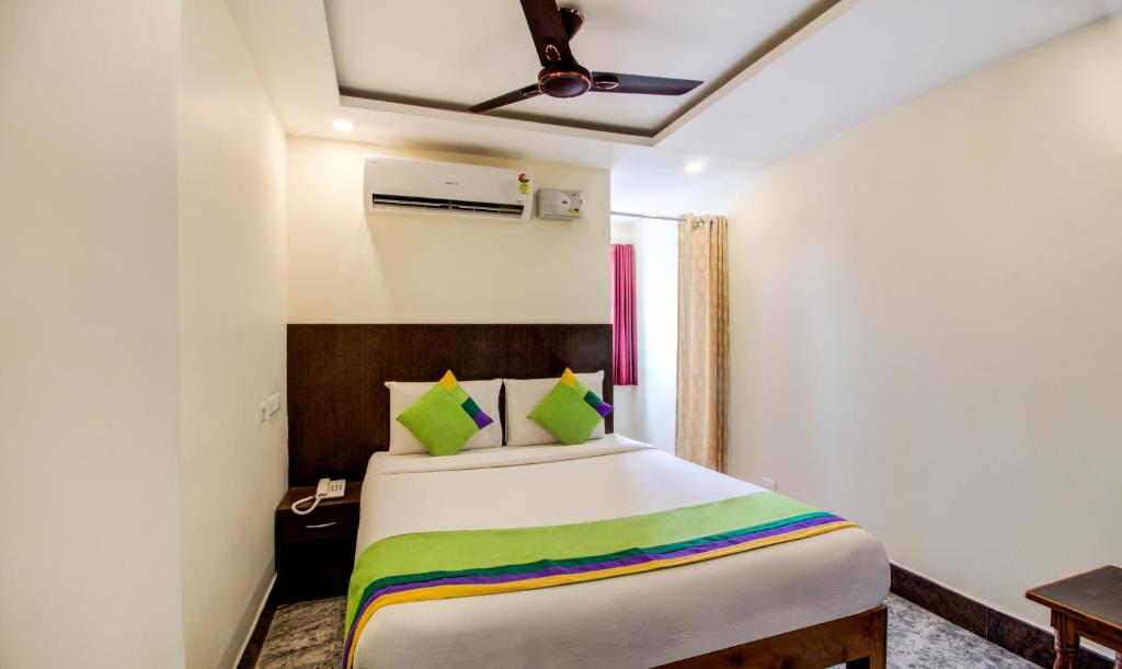 a bedroom with a large bed with a colorful blanket at Treebo Trend Sls Grand in Tirupati