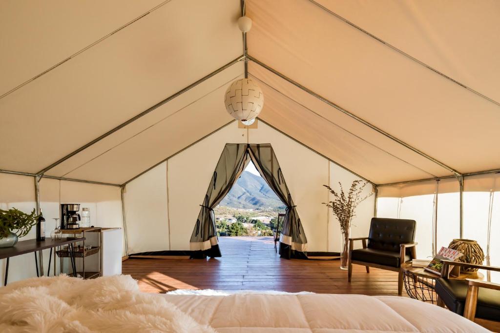 a room with a tent with a bed and a chair at Casa Misiones Glamping in Valle de Guadalupe