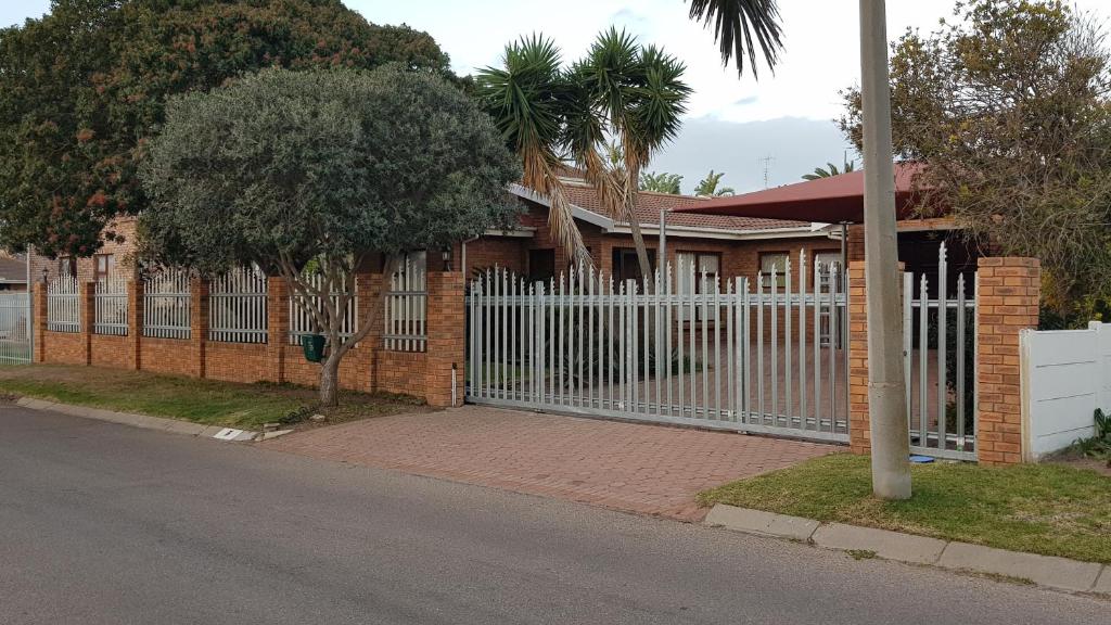 a white fence in front of a house at Bayview Selfcatering Apartment in Hartenbos