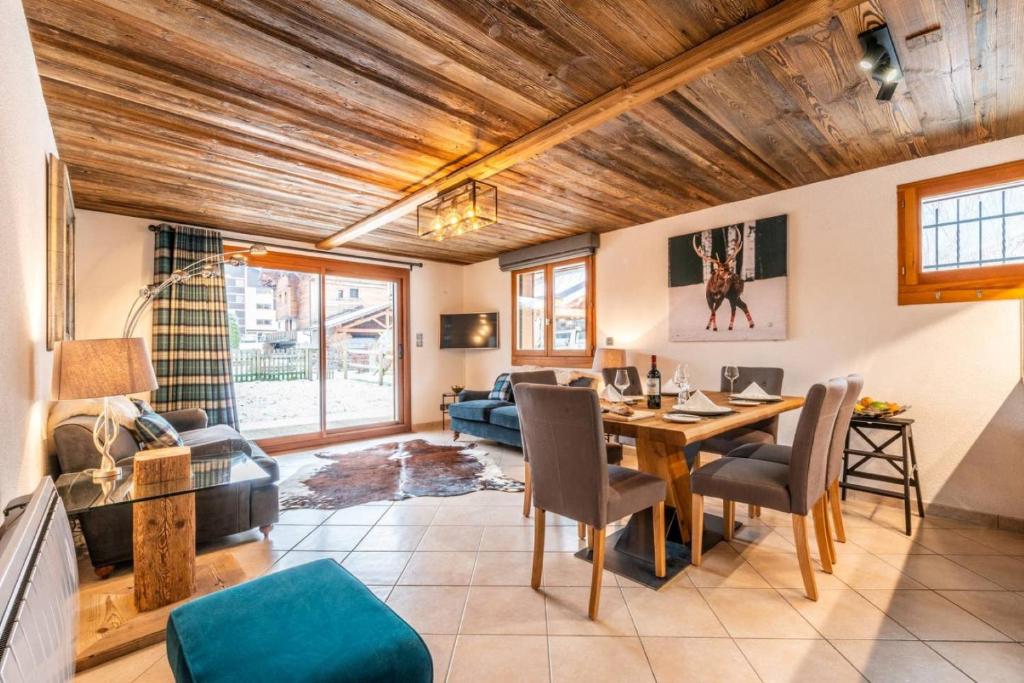 un salon avec un plafond en bois et une table et des chaises dans l'établissement JEANETTE 4, à Morzine