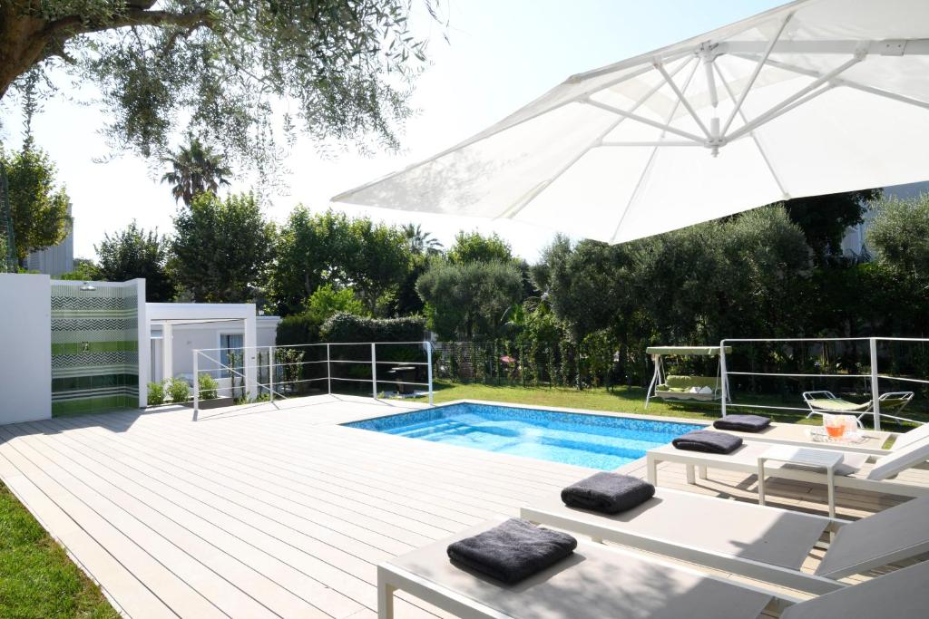 a swimming pool with an umbrella and chairs and a table and an umbrella at Villa Massa Residence in Sant'Agnello
