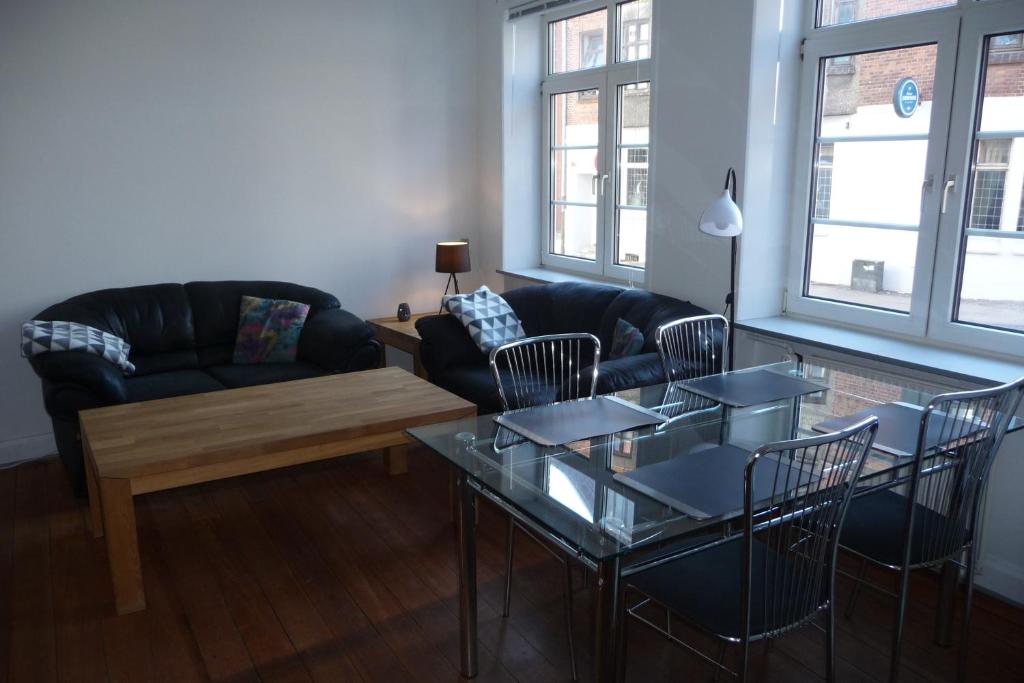 ein Wohnzimmer mit einem Sofa, einem Tisch und Stühlen in der Unterkunft Stor lejlighed midt i Sønderborg by. in Sønderborg