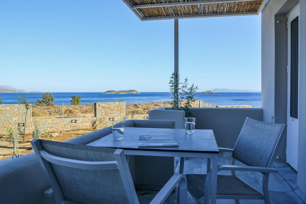 a table and chairs on a balcony with a view of the ocean at Pharos Apartments in Gavrio