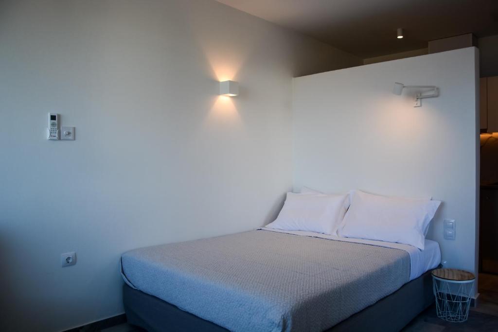 a small bedroom with a bed with blue sheets and pillows at Pharos Apartments in Gavrio