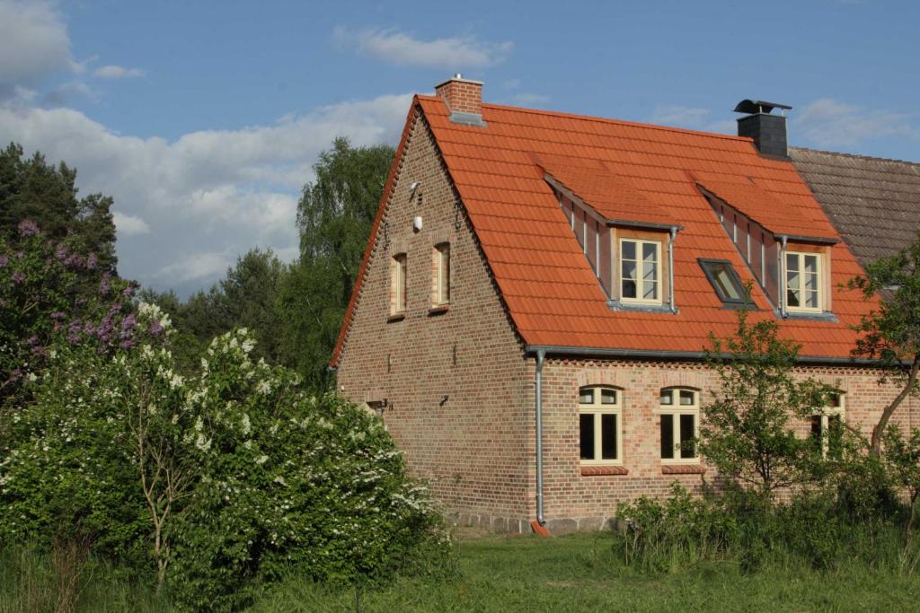 una antigua casa de ladrillo con techo naranja en Ferienhaus Amalienhof en Boek