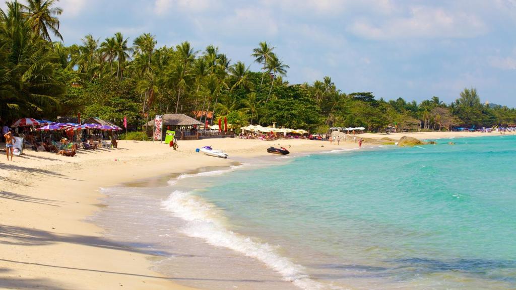 a beach with a group of people and the ocean at Samui Beach Residence Hotel in Chaweng