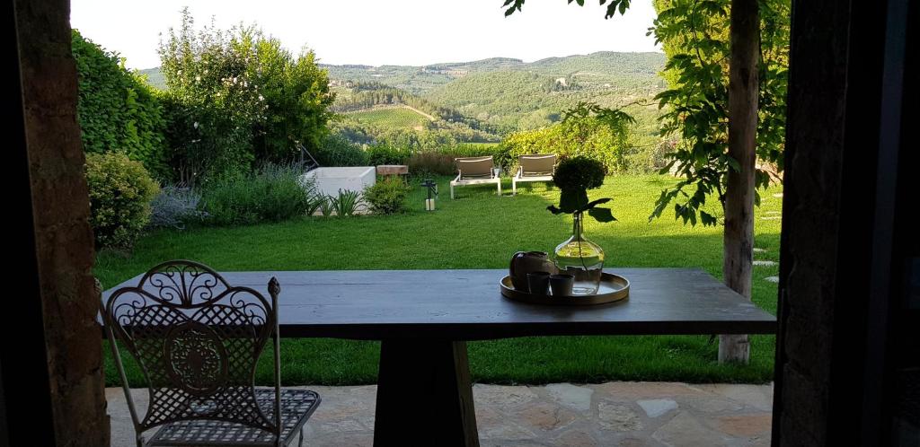 una mesa con un jarrón de flores encima en StageROOM03 - Chianti, en Castellina in Chianti