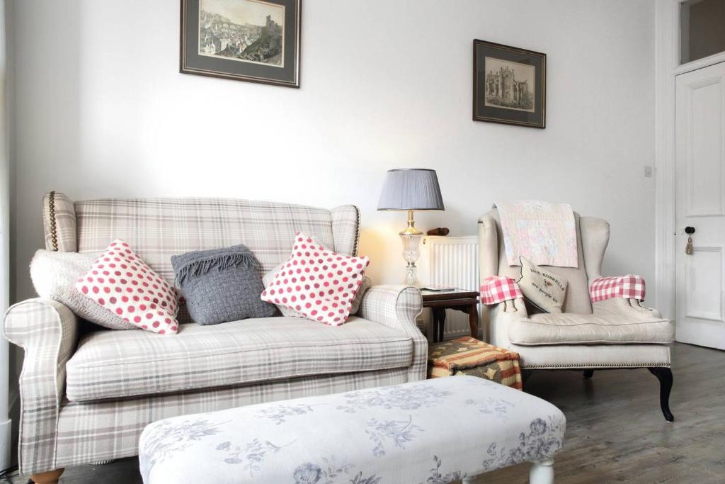 een woonkamer met een bank en 2 stoelen bij 5 star beautiful & vintage, spacious apt in chic location! in Edinburgh
