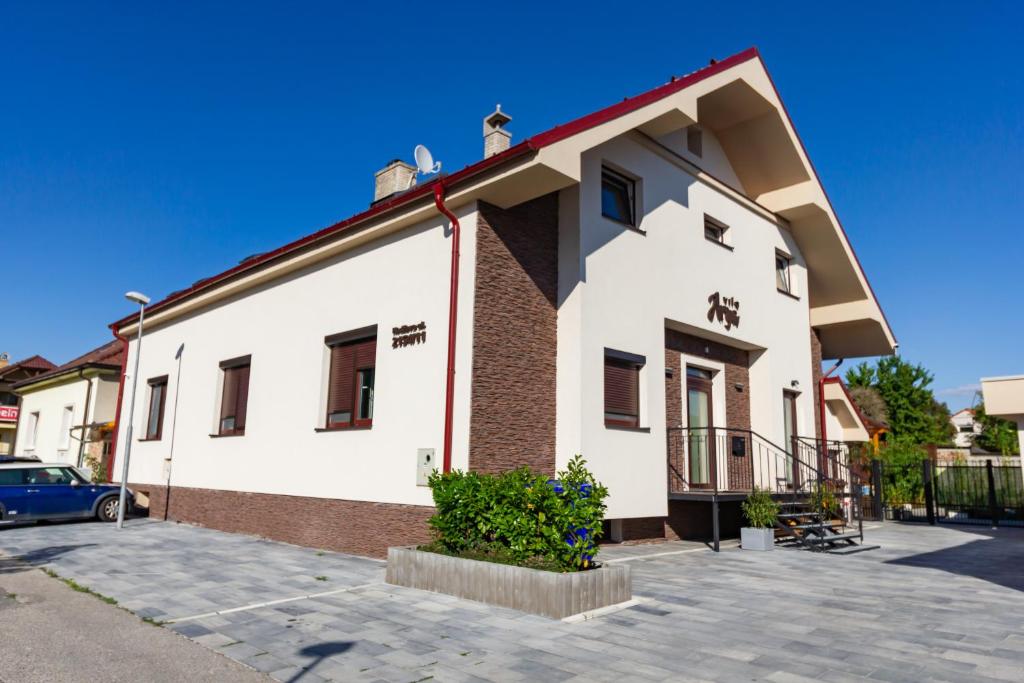 un bâtiment blanc et rouge avec un parking dans l'établissement Arya vila, à Piešťany