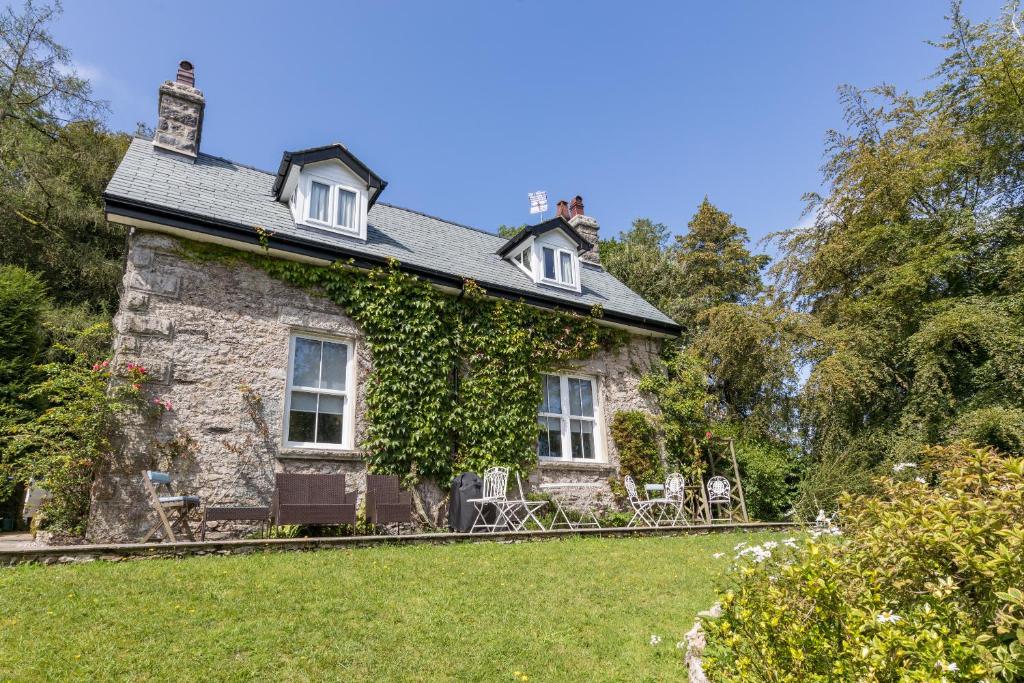 una vieja casa de piedra con hiedra creciendo en ella en Woodhaven - Luxury 4 bedroom rural retreat with hot tub near to Lake District, en Grange-over-Sands