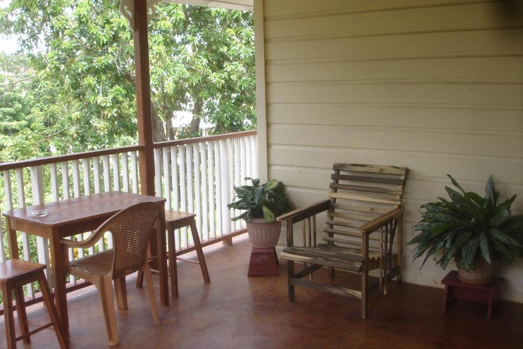 a porch with a table and chairs and a table and chairs at Finjam Cottage in Port Antonio