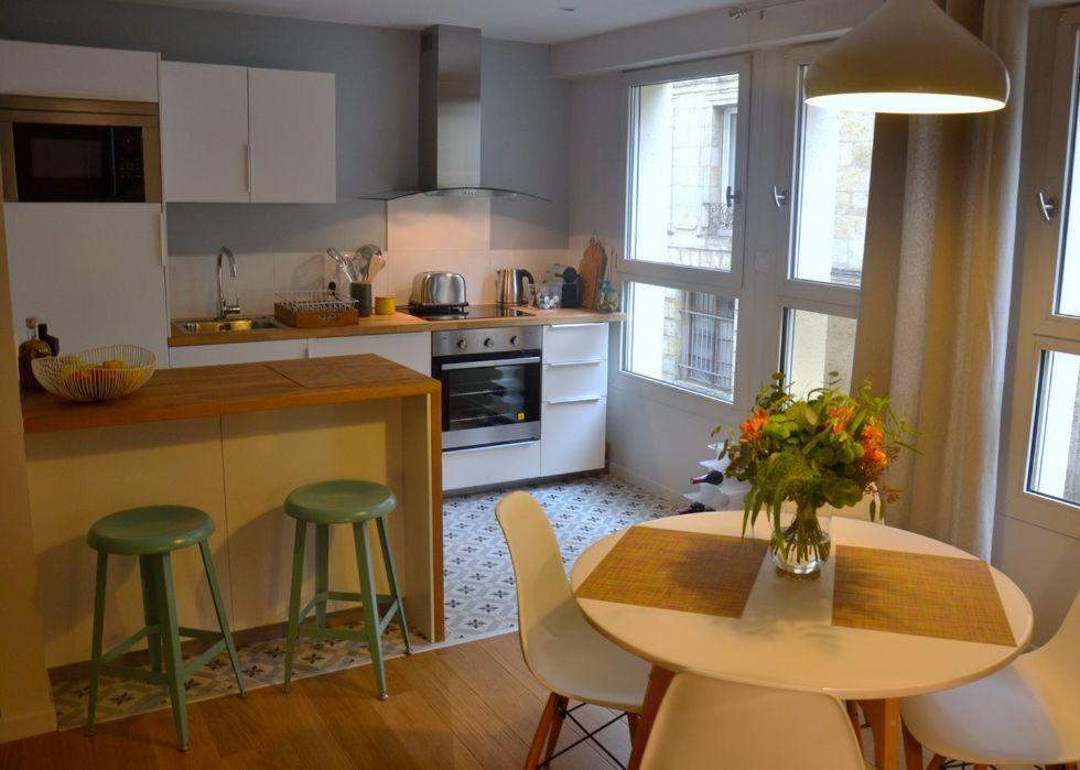 a kitchen with a table and chairs and a table with flowers at Burdigala Homes - Appart de Lalande in Bordeaux