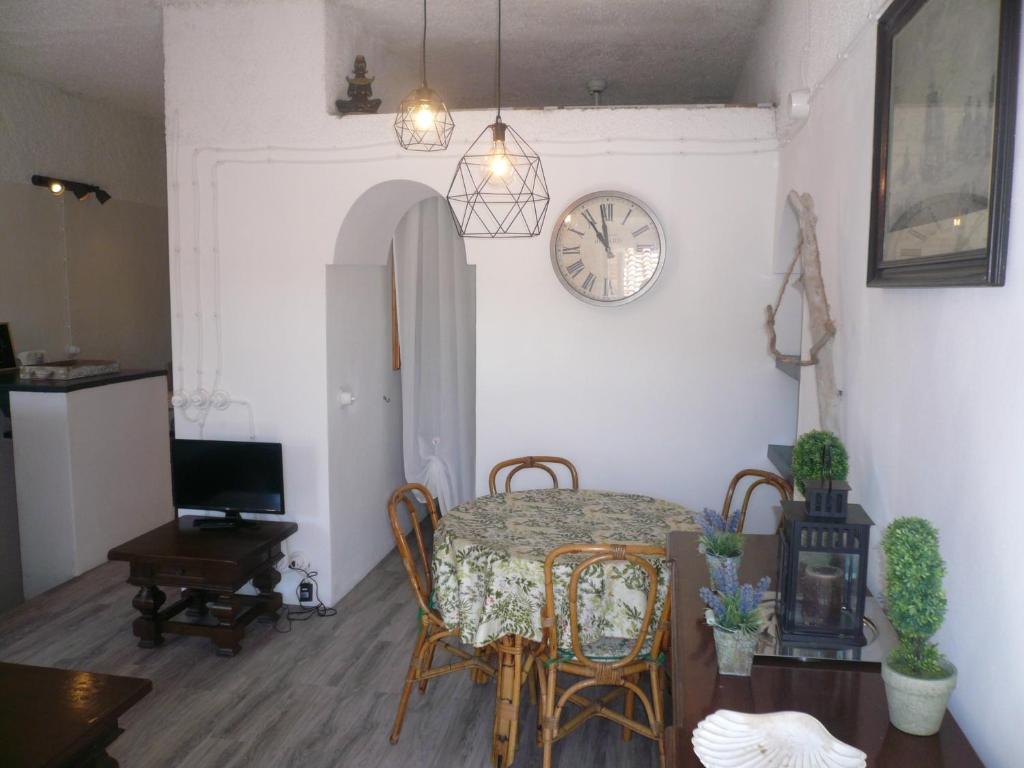 a dining room with a table and a clock on the wall at Appartamento Stellamares in Marciana