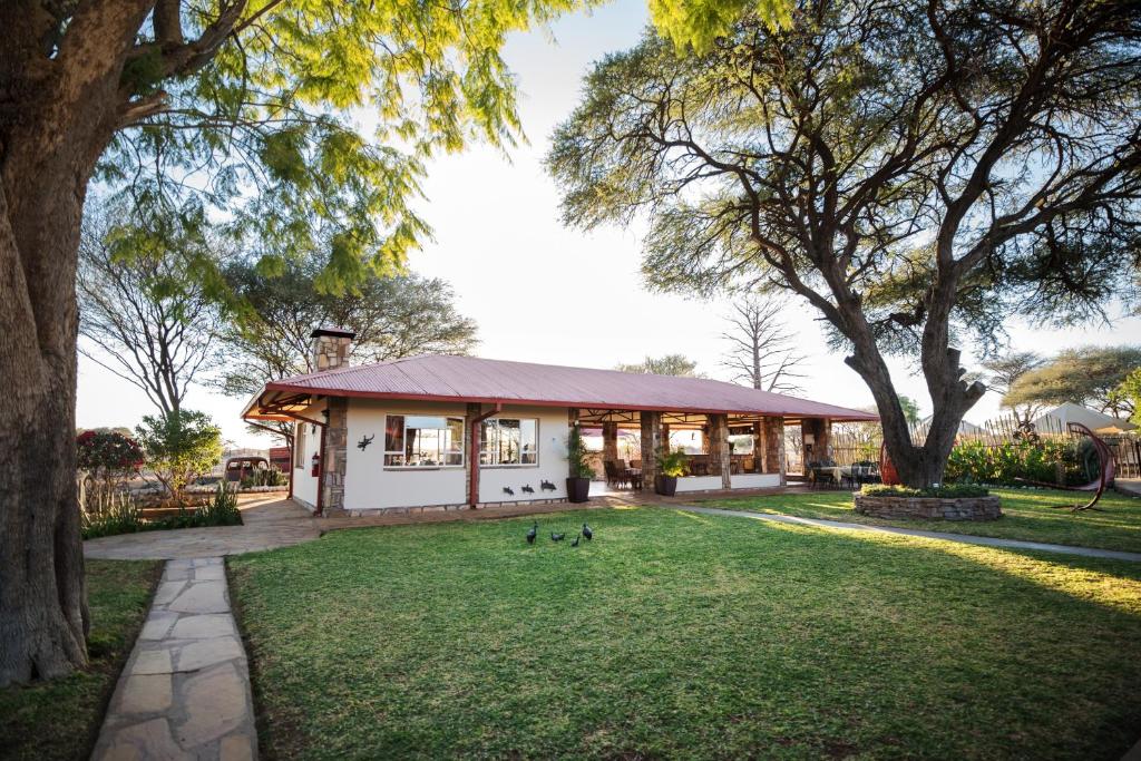 a house with two ducks in the grass at Dornhuegel Guest Farm in Groutfontein