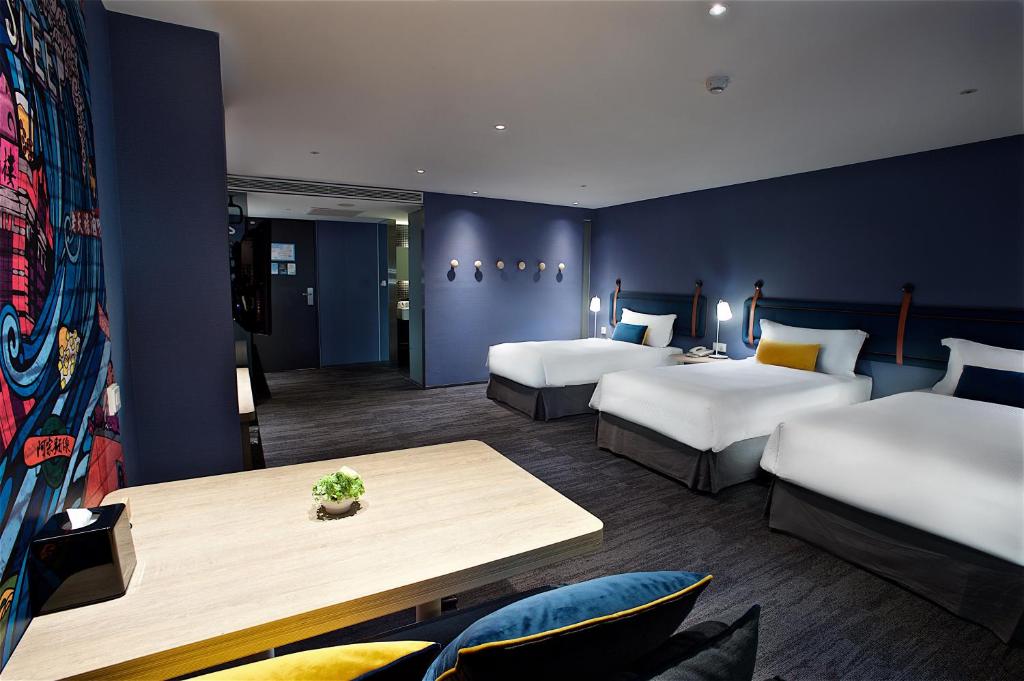 um quarto de hotel com duas camas e uma mesa em Just Sleep - Ximending em Taipei