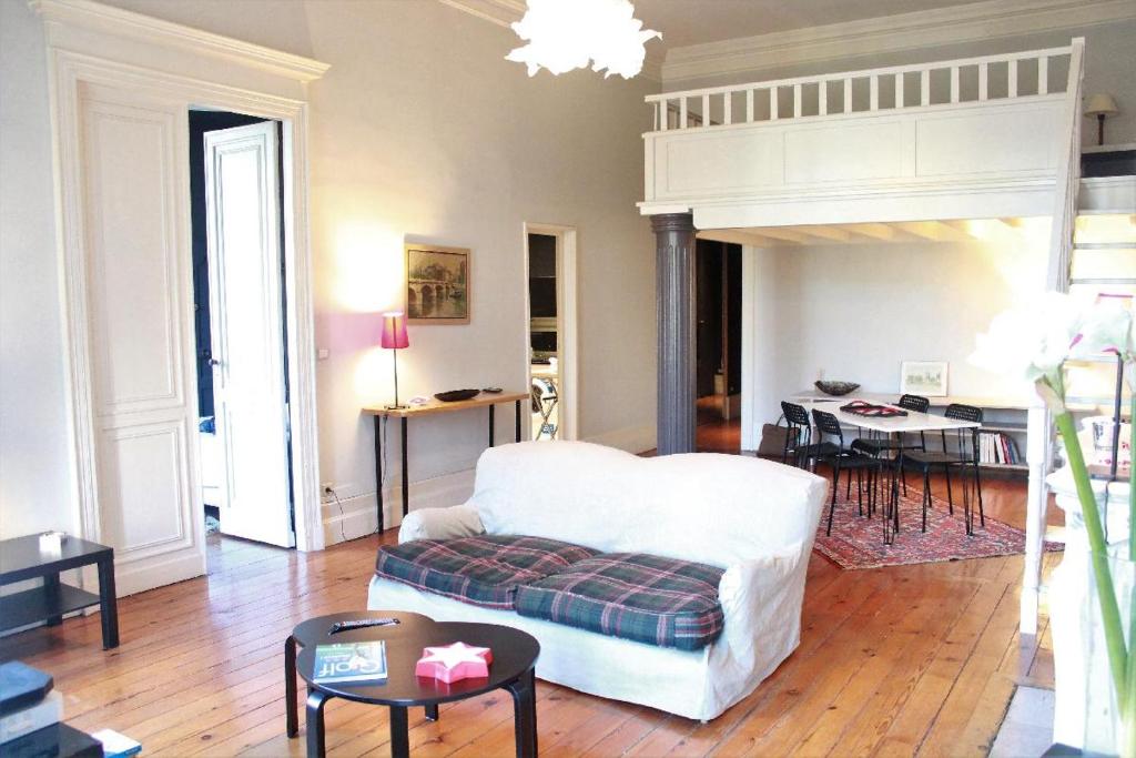 a living room with a bed and a table at Burdigala Homes - Appart Clemenceau in Bordeaux