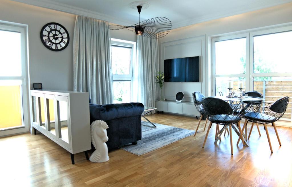 a living room with a couch and a table and chairs at Blue Velvet Premium Apartments II in Toruń