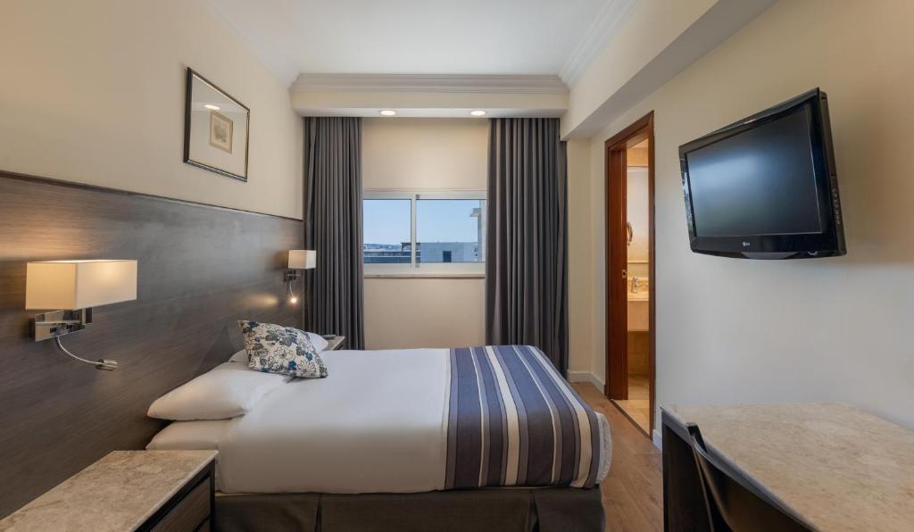 Postel nebo postele na pokoji v ubytování Ambassador Hotel