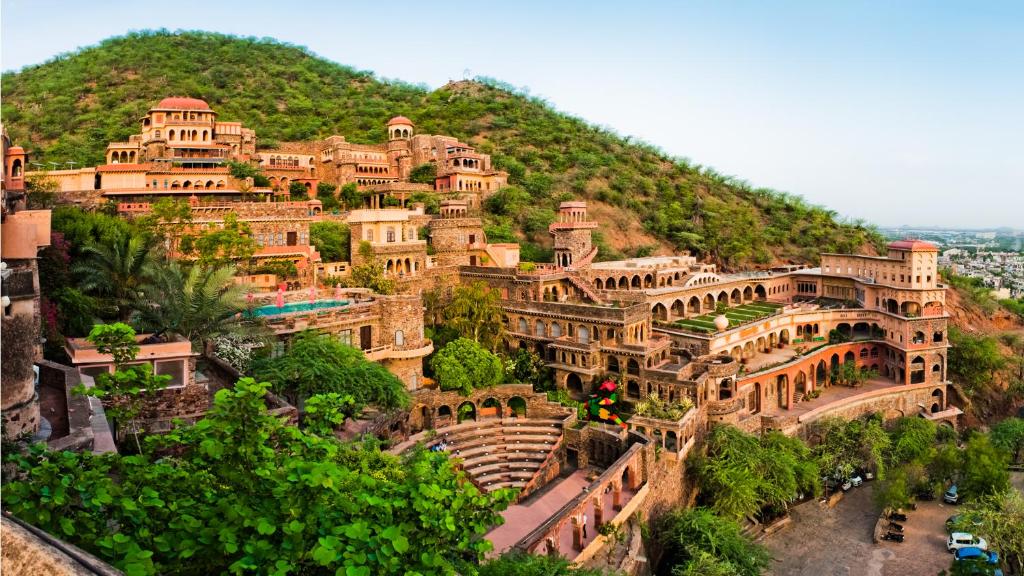 a large building on the side of a hill at Neemrana Fort-Palace in Neemrana