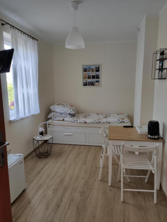 een slaapkamer met een bed en een tafel en stoelen bij Pokoje w Słonecznym Domku in Rowy