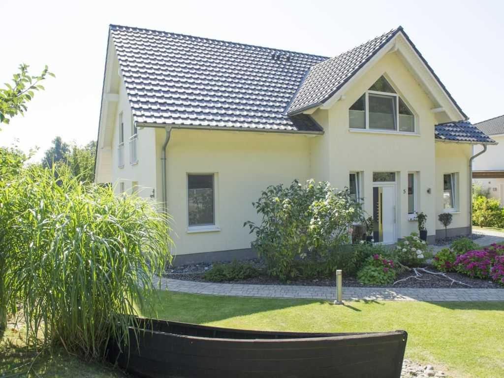 een wit huis met een zwart dak bij Ferienwohnung am Waldesrand in Ostseebad Sellin