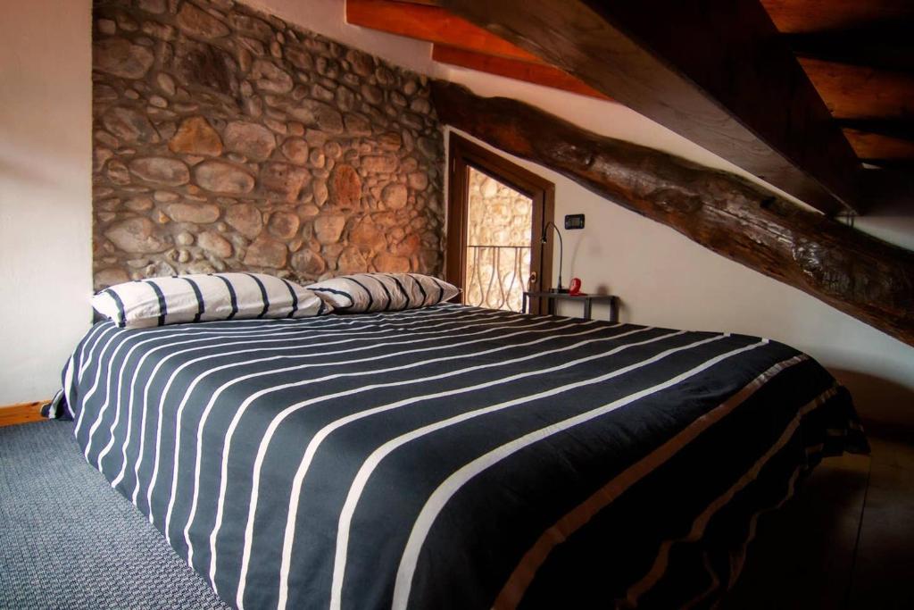 波爾托瓦爾特拉瓦利亞的住宿－Piccola casa vacanze - Small vacation house，一张大床,位于一个石墙房间内