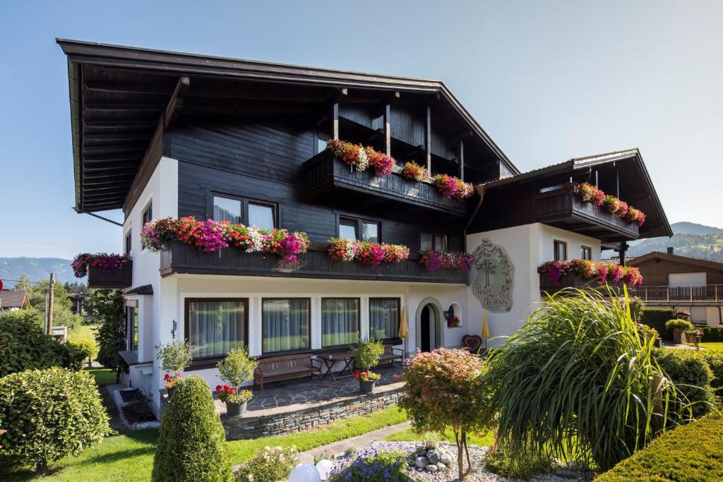 una casa en blanco y negro con cajas de flores en Pension Rofan en Reith im Alpbachtal