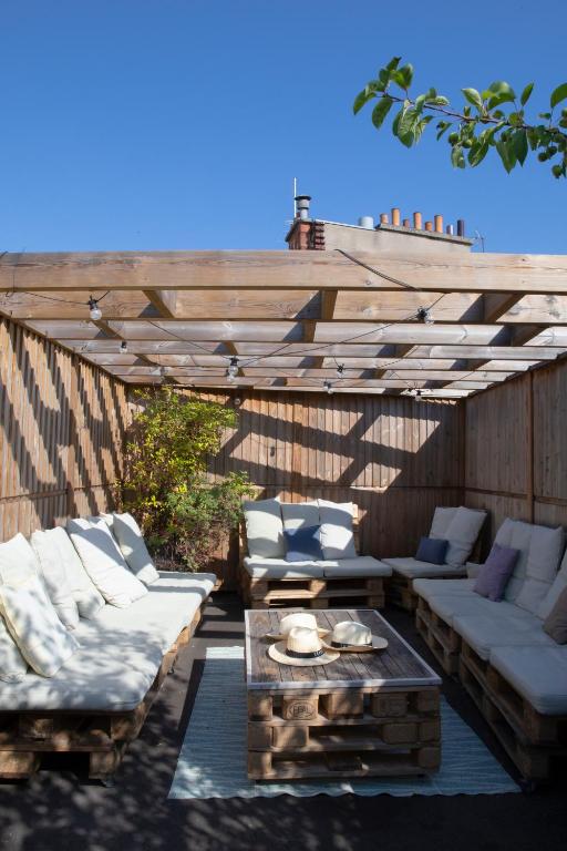 a patio with white couches and a wooden pergola at Terrass&quot; Hotel in Paris