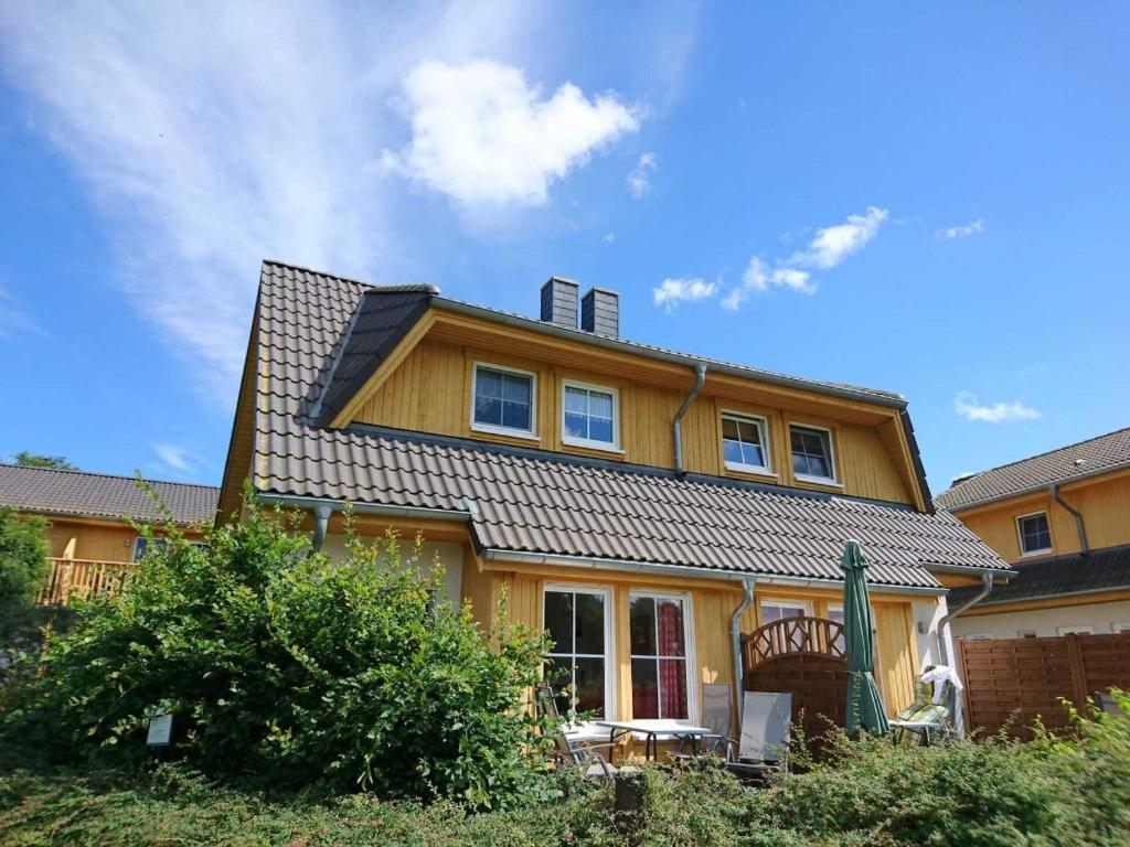 ein großes gelbes Haus mit einem Gameradach in der Unterkunft Hauptstrasse 14 DHH in Ostseebad Koserow